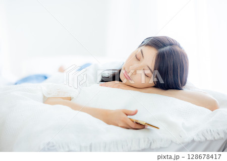 ベッドで寝ている女性 128678417