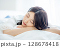 寝室で寝る若い女性 128678418