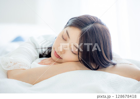 寝室で寝る若い女性 128678418
