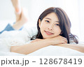 寝室で目覚める若い女性 128678419