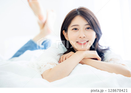 寝室で目覚める若い女性 128678421