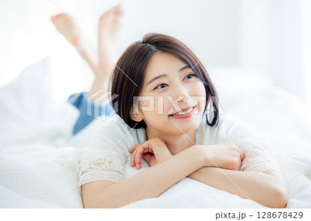 寝室で目覚める若い女性 128678429