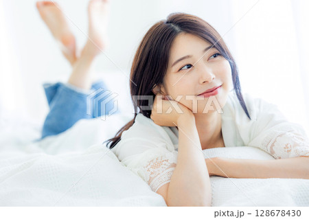 寝室で目覚める若い女性 128678430