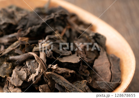 スプーンに載せた烏龍茶の茶葉のクローズアップ スプーンに載せた烏龍茶の茶葉のクローズアップ 128678655