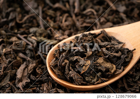 スプーンに載せた烏龍茶の茶葉のクローズアップ スプーンに載せた烏龍茶の茶葉のクローズアップ 128679066