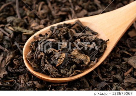 スプーンに載せた烏龍茶の茶葉のクローズアップ スプーンに載せた烏龍茶の茶葉のクローズアップ 128679067