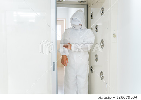 エアーシャワー・クリーンルームのある工場で働く人 エアーシャワー・クリーンルームのある工場で働く人 128679334