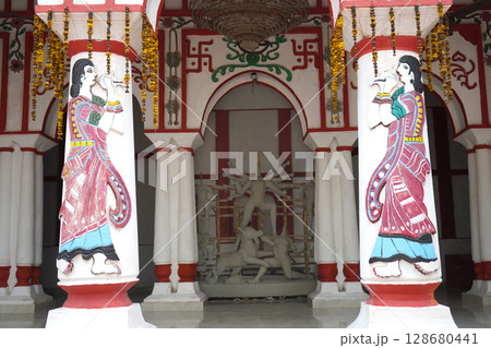 Traditional Bengali Courtyard with Unfinished Durga Idol and Decorative Painted Pillars 128680441