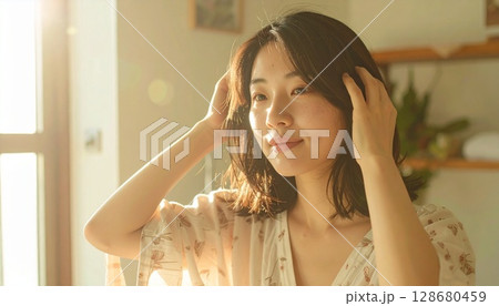 朝の鏡前で髪をとかす日本人女性 朝の鏡前で髪をとかす日本人女性 128680459