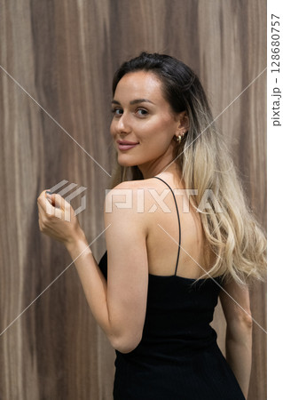 Elegant Blonde in a Black Dress Exuding Confidence and Timeless Beauty. Elegant Blonde in a Black Dress Exuding Confidence and Timeless Beauty. 128680757