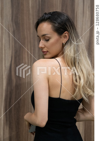 Elegant Blonde in a Black Dress Exuding Confidence and Timeless Beauty. Elegant Blonde in a Black Dress Exuding Confidence and Timeless Beauty. 128680758