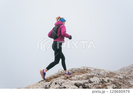 Trail Runner in Misty Mountain Landscape Trail Runner in Misty Mountain Landscape 128680979