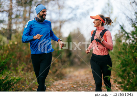 Happy Couple Running on a Forest Trail Happy Couple Running on a Forest Trail 128681042