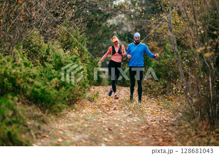 Happy Couple Running on a Forest Trail Happy Couple Running on a Forest Trail 128681043