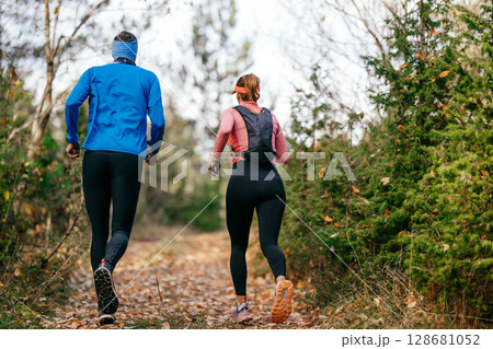 Happy Couple Running on a Forest Trail Happy Couple Running on a Forest Trail 128681052
