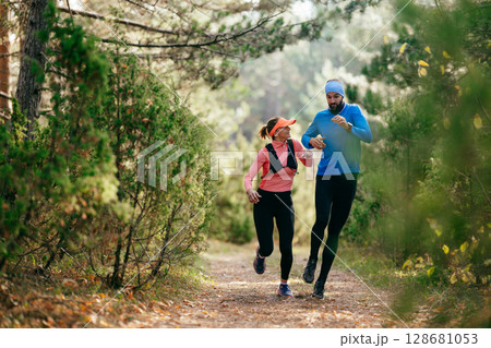 Happy Couple Running on a Forest Trail Happy Couple Running on a Forest Trail 128681053