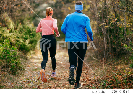 Happy Couple Running on a Forest Trail Happy Couple Running on a Forest Trail 128681056