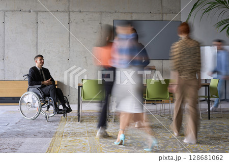 A diverse business team, working urgently around a conference table, collaborates on a meeting while their director, seated in a wheelchair, waits for their input A diverse business team, working urgently around a conference table, collaborates on a meeting while their director, seated in a wheelchair, waits for their input 128681062