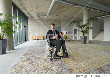 A director in a wheelchair sitting alone in an empty office, deeply reflecting on business strategies and decisions, contemplating the path forward with focused determination. 128681068