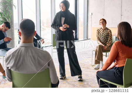 Corporate business team meeting with a manager or coach. Group of happy diverse, multiracial people sitting in a circle  128681131