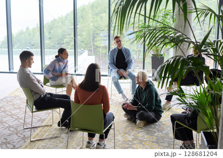 Corporate business team meeting with a manager or coach. Group of happy diverse, multiracial people sitting in a circle Corporate business team meeting with a manager or coach. Group of happy diverse, multiracial people sitting in a circle 128681204