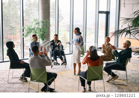 Corporate business team meeting with a manager or coach. Group of happy diverse, multiracial people sitting in a circle  128681221