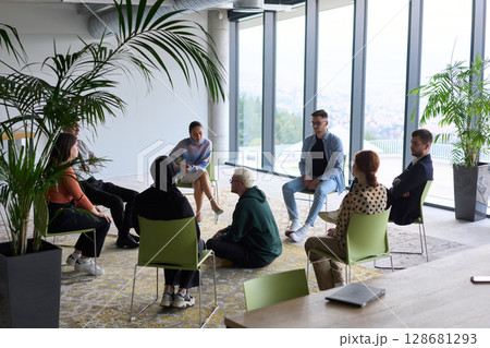 Corporate business team meeting with a manager or coach. Group of happy diverse, multiracial people sitting in a circle  128681293