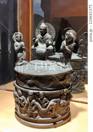 ガンダーラの中心都市パキスタンのペシャワル博物館に展示される釈迦三尊像のある貴重な仏舎利容器 ガンダーラの中心都市パキスタンのペシャワル博物館に展示される釈迦三尊像のある貴重な仏舎利容器 128681375