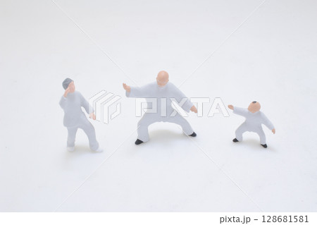 Miniature Figurine of a Martial Artist in Combat Pose Over White Background Miniature Figurine of a Martial Artist in Combat Pose Over White Background 128681581