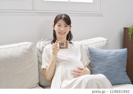 自宅でカフェインレスコーヒーを飲む妊婦　カメラ目線 128681992