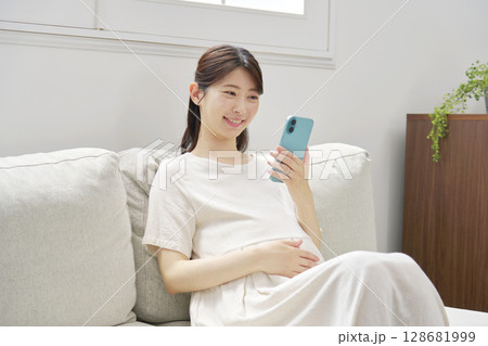 スマートフォンを使う妊婦　リビング 128681999