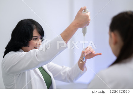Two scientists holding test tubes with yellow liquid Two scientists holding test tubes with yellow liquid 128682099