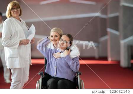 Doctor checking patients progress in wheelchair Doctor checking patients progress in wheelchair 128682140