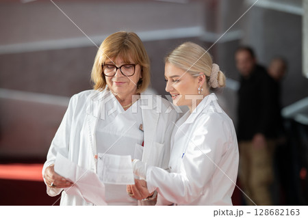 Group of female doctors reviewing medical document 128682163