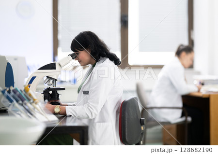 Doctor scientist using microscope in laboratory 128682190