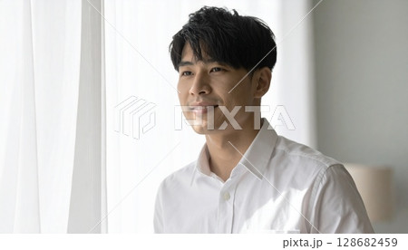 窓辺で爽やかな白シャツの若い男性 128682459