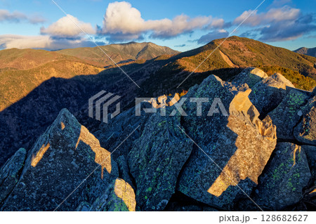 朝の乾徳山山頂から見る黒金山と国師岳 128682627