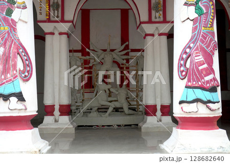Symmetrical View of Unfinished Durga Idol in Heritage Courtyard with Painted Pillars 128682640