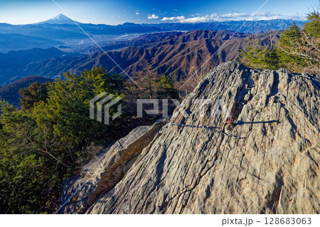 乾徳山稜線の鎖場と朝の富士山 128683063