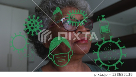 Image of pandemic icons over senior african american woman at home Image of pandemic icons over senior african american woman at home 128683139