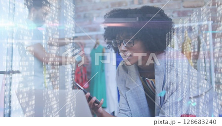 Screens with data processing against african american female fashion designer talking on smartphone 128683240