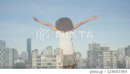 Image of cityscape over african american woman with arms outstretched Image of cityscape over african american woman with arms outstretched 128683569