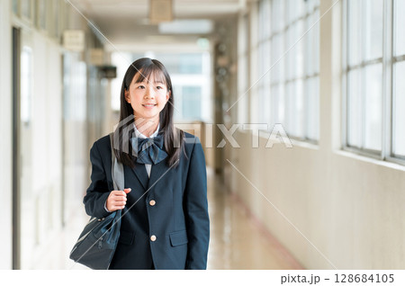 学校の廊下を歩く制服姿の小学生,中学生,高校生の女子生徒 128684105