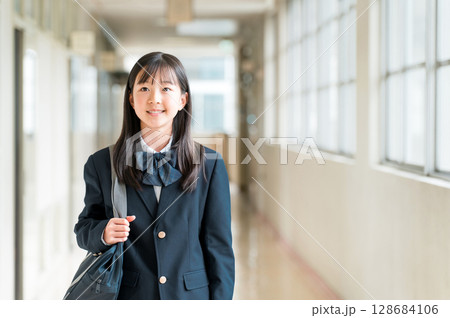 学校の廊下を歩く制服姿の小学生,中学生,高校生の女子生徒 128684106