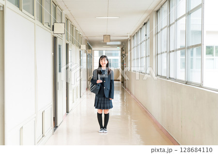 学校の廊下を歩く制服姿の小学生,中学生,高校生の女子生徒 学校の廊下を歩く制服姿の小学生,中学生,高校生の女子生徒 128684110