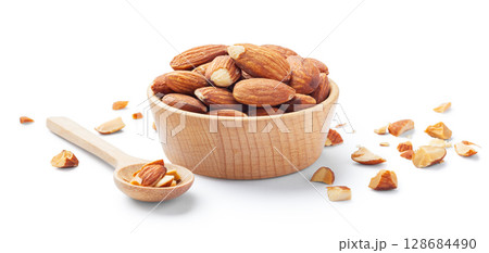 Almonds in wood bowl with broken almond nuts and spoon isolated on white background Almonds in wood bowl with broken almond nuts and spoon isolated on white background 128684490