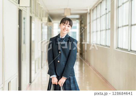 学校の廊下を歩く制服姿の小学生,中学生,高校生の女子生徒 128684641