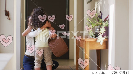 Image of falling hearts over african american mother and daughter hugging 128684951