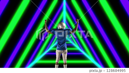 Image of african american male american football player raising hands over shapes 128684995