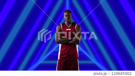 Image of african american male basketball player with arms crossed over shapes 128685002